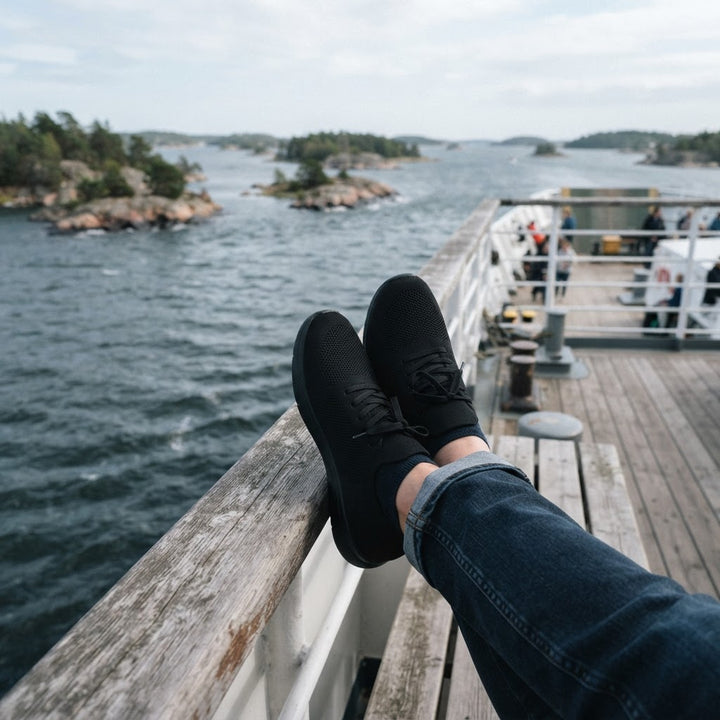 Svarta stickade sneakers på relingen av en skärgårdsbåt