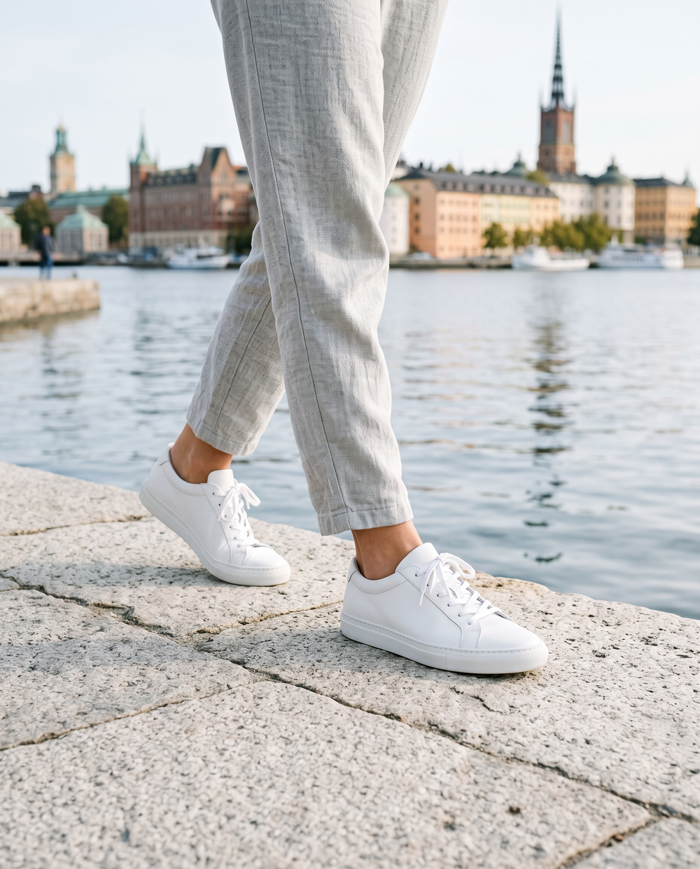 Kvinna i vita bekväma sneakers vid vattnet i Stockholm
